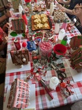 Gingerbread Party: A photo of a table, covered in gingerbread houses in varying states of decoration