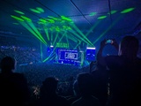 A very blue photo of the interior of Rod Laver Arena, lit up with The Killers on stage